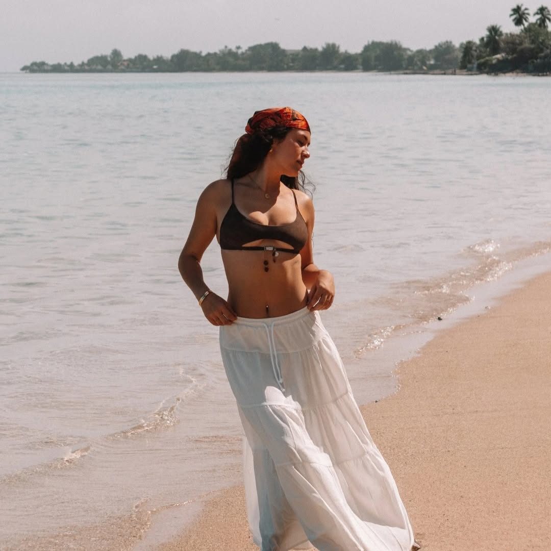Femme marchant sur la plage en jupe blanche